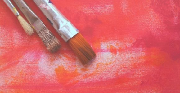 paintbrushes on red background