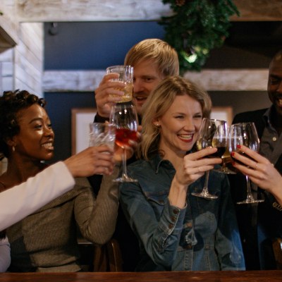 blonde woman enjoying festive drinks with friends in bar